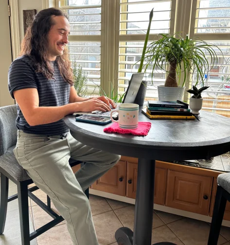 Gabe working on digital marketing strategies for a client on his laptop at home. 